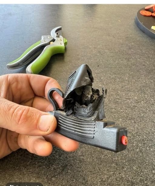 A badly burnt and melted electrical connector held up in the workshop.